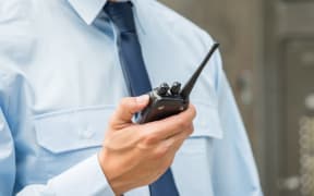 Security Guard Holding Walkie-talkie.