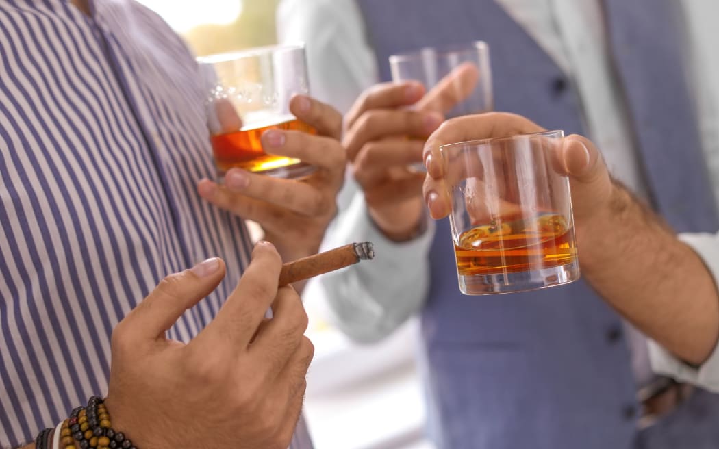 Group of friends drinking whiskey together indoors, closeup