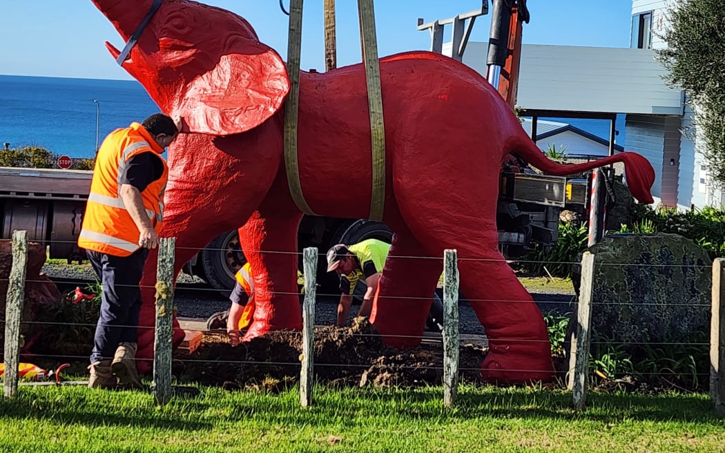 The red elephant is lowered into place at its new home in Langs Beach. Photo: Kate Harris
