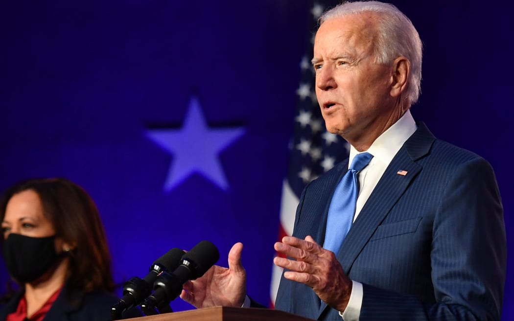Democratic vice presidential nominee Senator Kamala Harris listens as Democratic presidential nominee Joe Biden delivers remarks at the Chase Center in Wilmington, Delaware, on November 6, 2020.