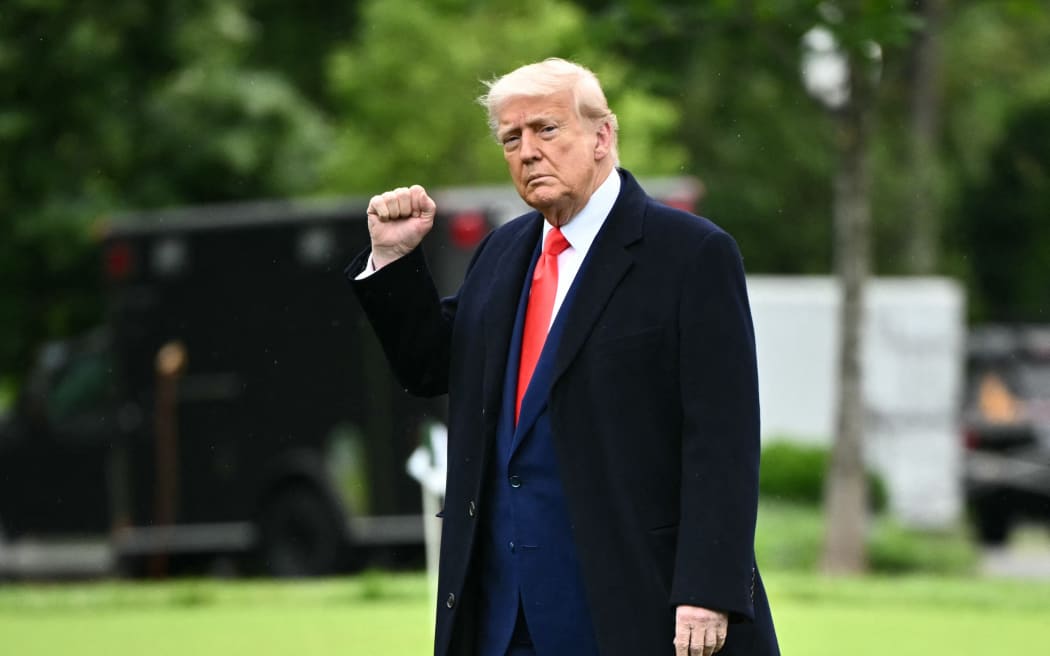 US President Donald Trump raises a fist as he makes his way to board Marine One before departing from the South Lawn of the White House in Washington, DC on May 22, 2025.