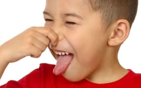 A child holding his nose
