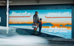 A mural of a man and child fishing, with the text “Māori roll or general roll? Breathe mana into your choice.”