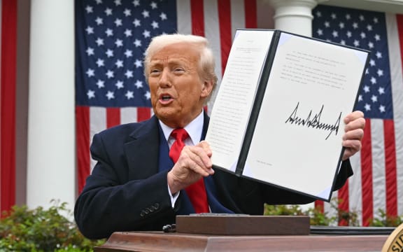 US President Donald Trump holds a signed executive order after delivering remarks on reciprocal tariffs during an event in the Rose Garden entitled "Make America Wealthy Again" at the White House in Washington, DC, on April 2, 2025. Trump geared up to unveil sweeping new "Liberation Day" tariffs in a move that threatens to ignite a devastating global trade war. Key US trading partners including the European Union and Britain said they were preparing their responses to Trump's escalation, as nervous markets fell in Europe and America. (Photo by SAUL LOEB / AFP)