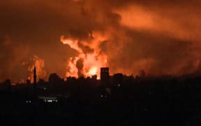 This image grab from an AFP TV footage shows balls of fire rising above Gaza City during an Israeli strike on October 27, 2023, as battles between Israel and the Palestinian Hamas movement continue. (Photo by AFP)
