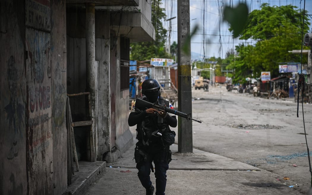 Police officers patrol a neighborhood amid gang-related violence in downtown Port-au-Prince on April 25, 2023. Between April 14 and 19, clashes between rival gangs left nearly 70 people dead, including 18 women and at least two children, according to a United Nations statement released April 24. (Photo by Richard PIERRIN / AFP)