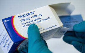 01 March 2022, Berlin: A person holds the drug Paxlovid from the US pharmaceutical company Pfizer against Covid-19. Photo: Fabian Sommer/dpa (Photo by Fabian Sommer / DPA / dpa Picture-Alliance via AFP)