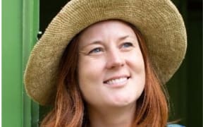 Kate Evans smiling wearing a wide brimmed sun hat.