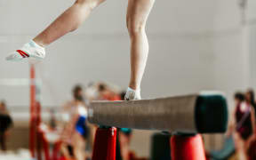 feet young athlete girls gymnast exercises on balance beam