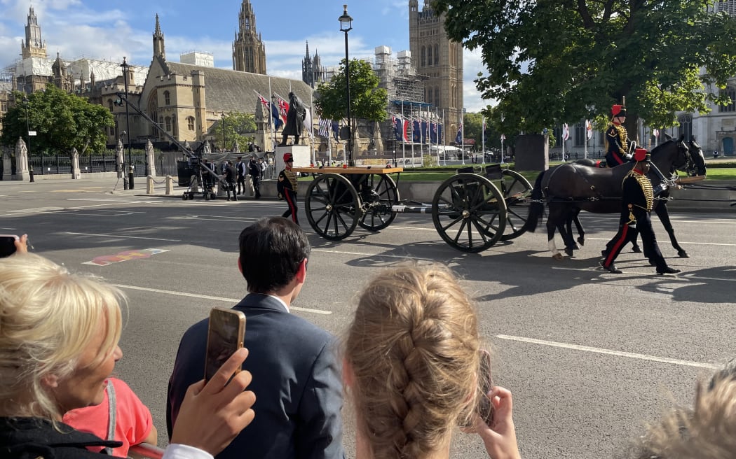 An empty carriage leaves Westminster Hall as people queue to pay respects to the Queen.