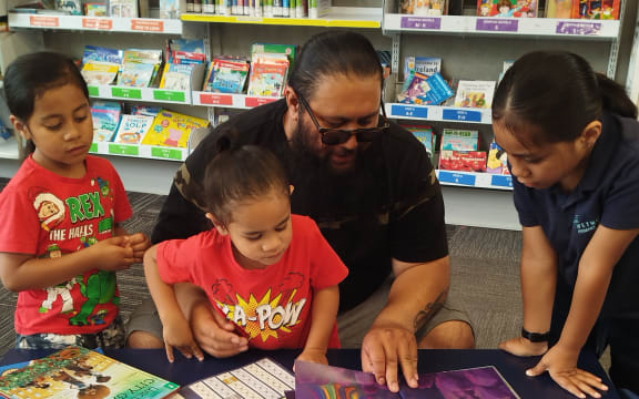 Lawren Matrix's family, Sila-Jay Matrix, Renzo Cruz Matrix, and John-Eze Matrix (Ngai Tūhoe) reading with their dad Jon Esekielu.
