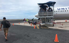 Steady out-migration to the United States is a major factor contributing to minimal population growth in the Marshall Islands. Here, passengers board a United Airlines flight departing Majuro.