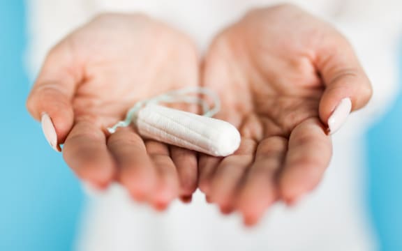 Woman holding a tampon, blue background