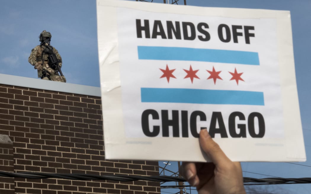 BROADVIEW, ILLINOIS - SEPTEMBER 12: Federal police officers watch from the rooftop as demonstrators protest outside of an immigration processing center on September 12, 2025 in Broadview, Illinois. The demonstrators were protesting the Trump administration's increase in immigration enforcement raids in the area which has been dubbed "Operation Midway Blitz".   Scott Olson/Getty Images/AFP (Photo by SCOTT OLSON / GETTY IMAGES NORTH AMERICA / Getty Images via AFP)