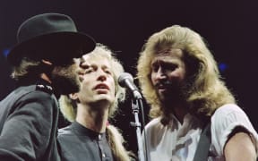 British band Bee Gees singer, Robin Gibb (C), flanked by his two brothers Maurice (L) and Barry (R), sings during a concert at Paris Bercy on June 23, 1991. Gibb, 62, died on May 21, 2012 after a lengthy battle with cancer. AFP PHOTO / BERTRAND GUAY (Photo by BERTRAND GUAY / AFP)
