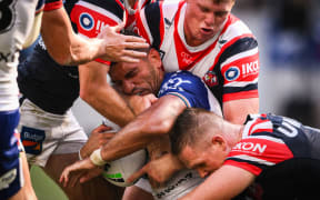Marcelo Montoya of the Warriors is tackled by Roosters players