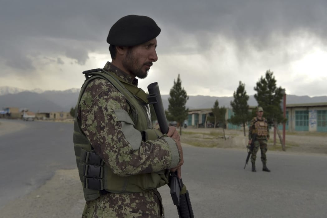 Afghan National Army (ANA) soldiers stand guard at a checkpoint near the a US military base in Bagram, some 50 km north of Kabul on April 29, 2021. (Photo by WAKIL KOHSAR / AFP)