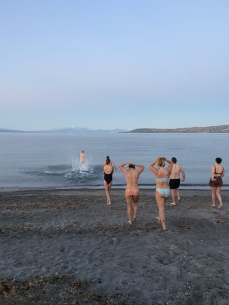 Swimmers run into Lake Taupō for a swim.