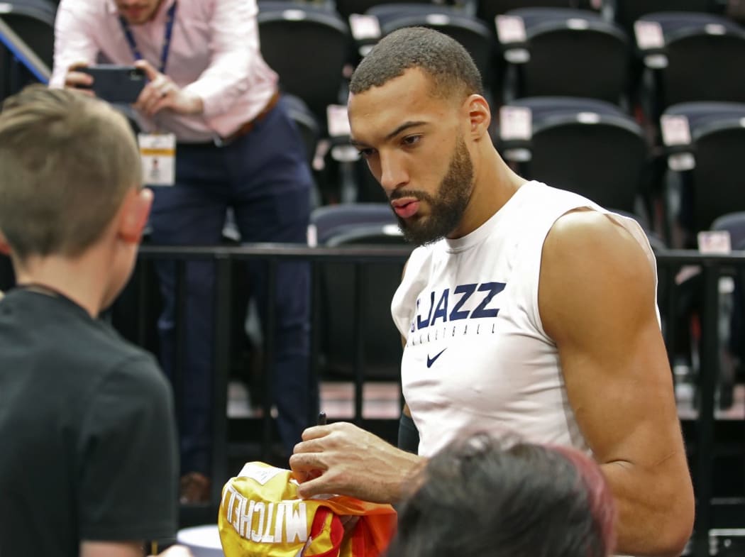 (FILES) In this file photo taken on December 04, 2019 Utah Jazz center Rudy Gobert signs autographs after warm ups, before a NBA game against Los Angeles Lakers in Salt Lake City, Utah. -
