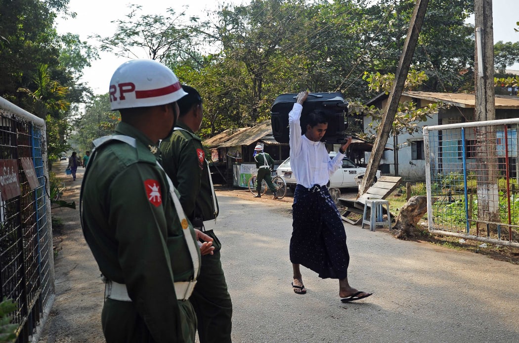 A former Myanmar child soldier (R) carries his belongings as he walks out from a military compound in Yangon after a ceremony discharging a group of children and young people back to their parents and guardians on January 18, 2014.