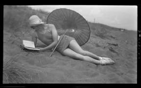 Woman reading at the beach December 1934