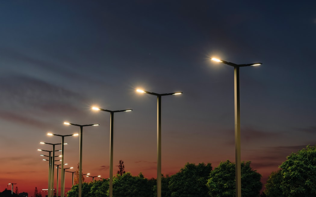 A modern street LED lighting pole. Urban electro-energy technologies. A row of street lights against the night sky.