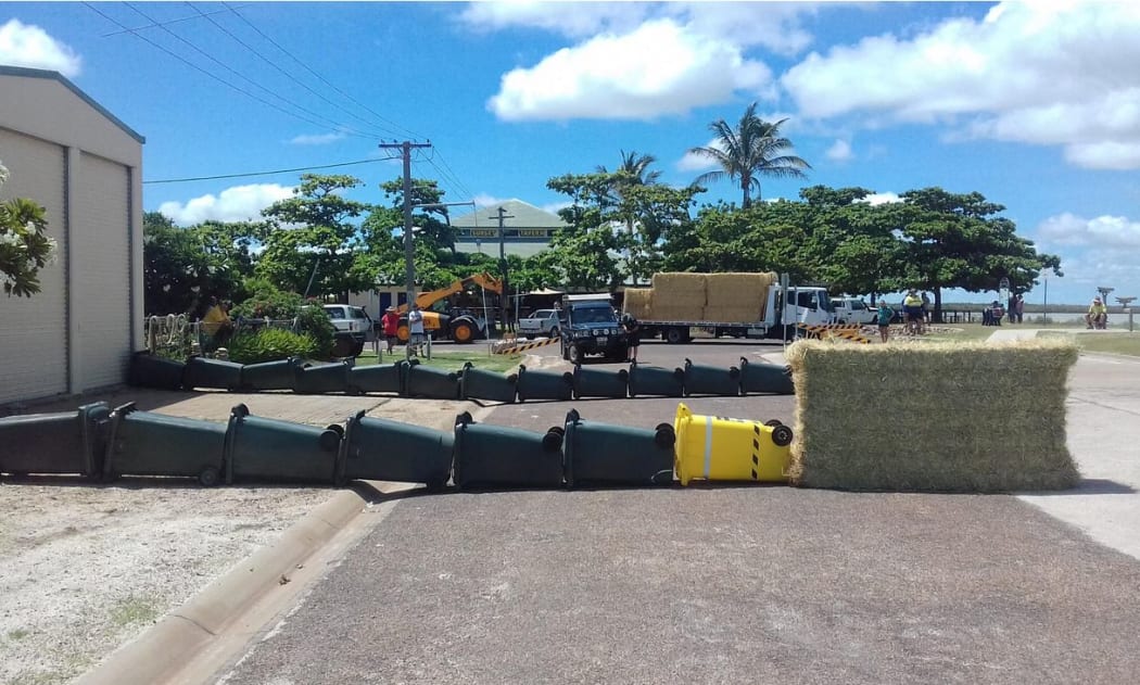 A group of Queensland residents have tried to lead a stray 3.8m crocodile back to the water's edge using a wall of wheelie bins.