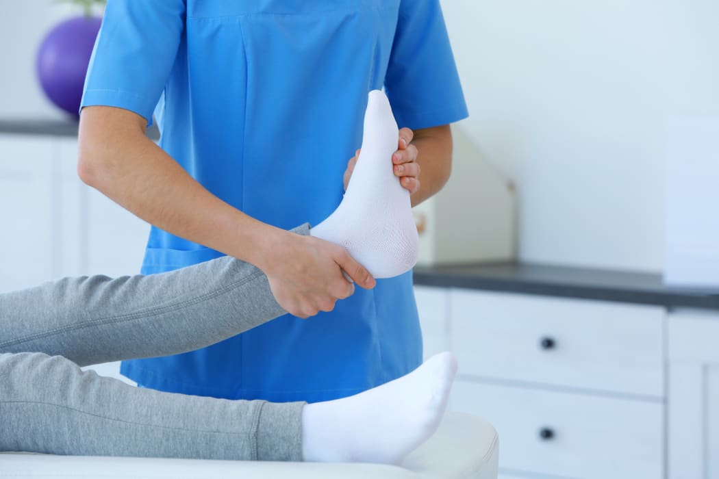 Physiotherapist working with patient in clinic, closeup