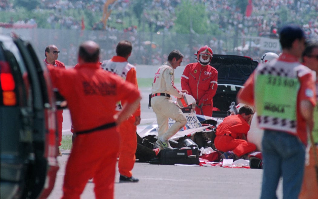 Personale medico e di sicurezza circondano l'auto distrutta di Ayrton Senna sul circuito di Imola dopo il suo incidente mortale al settimo giro del Gran Premio di San Marino.