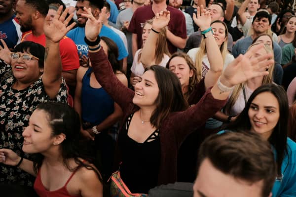 A diverse crowd of young smiling people is shown from above
