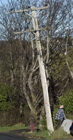 Fea St resident Jeff Gladden stands next to a power pole which he believes could fall across the street at any time. PHOTO: GERARD O’BRIEN