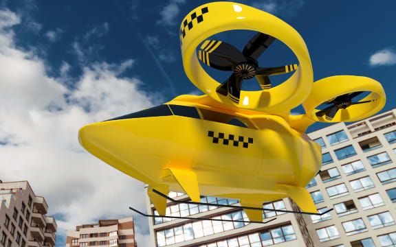 An air taxi flies through a city.