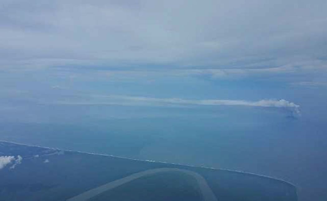Kadovar island emitting volcanic ash cloud seen in the distance from the south over the PNG mainland's north coast. The Sepik River can be seen in the foreground.