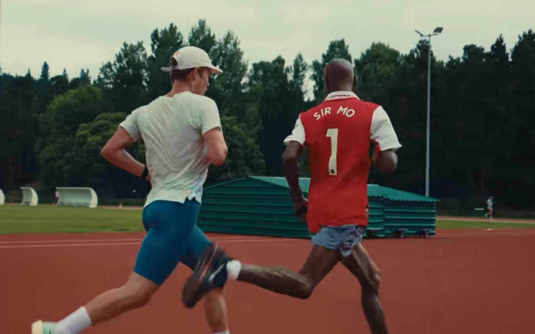 Legendary British runner Sir Mo Farah jumps on the track with New Zealand's Hayden Wilde in France in July 2025.