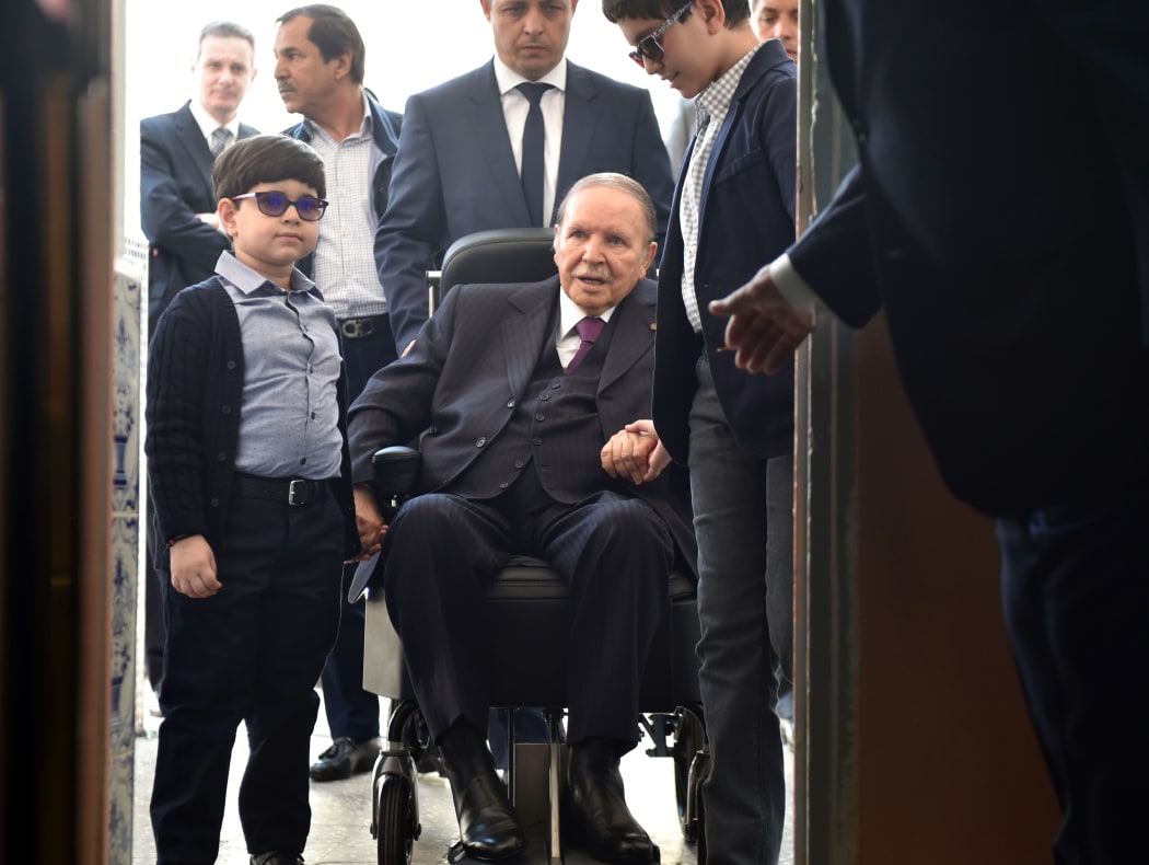 Algerian President Abdelaziz Bouteflika  arrives on a wheelchair to vote at a polling station in Algiers.
