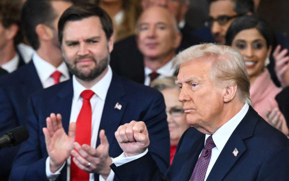 (L-R) US Vice President J.D. Vance applauds as President Donald Trump raises his fist after finishing his remarks after being sworn in as the 47th President in the US Capitol Rotunda in Washington, DC, on January 20, 2025. (Photo by SAUL LOEB / POOL / AFP)