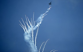 An F-15 fighter aircraft releases flares during the Singapore Airshow in Singapore on February 17, 2016.