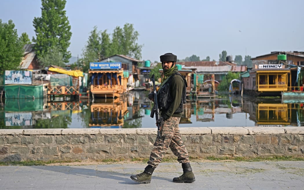 An Indian paramilitary personnel patrols along the banks of Dal Lake in Srinagar.