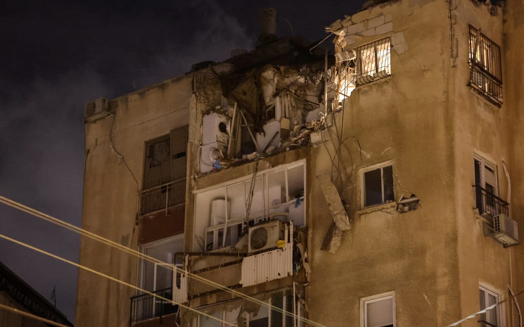 TOPSHOT - A building in Tel Aviv is damaged by a rocket fired by Palestinian militants from the Gaza Strip on October 7, 2023. Palestinian militant group Hamas launched a surprise large-scale attack against Israel on October 7, firing thousands of rockets from Gaza and sending fighters to kill or abduct people as Israel retaliated with devastating air strikes. (Photo by JACK GUEZ / AFP)
