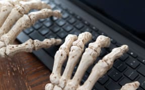 Skeleton hands typing on keyboard