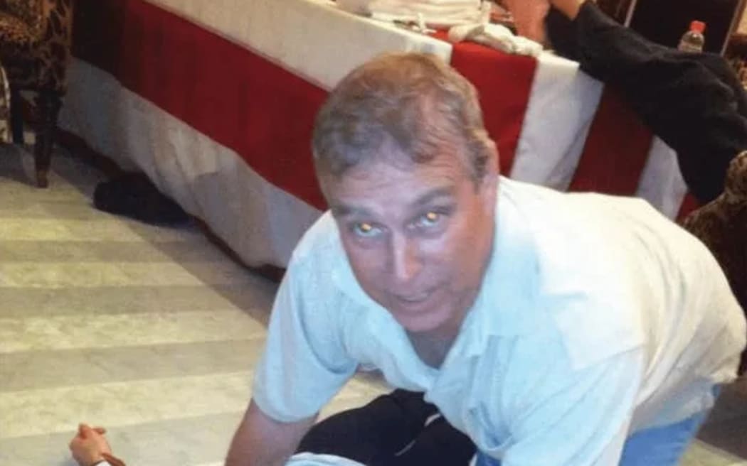 The former prince Andrew, seen kneeling over an unidentified woman in the latest tranche of files regarding Jeffrey Epstein, released by US officials.
