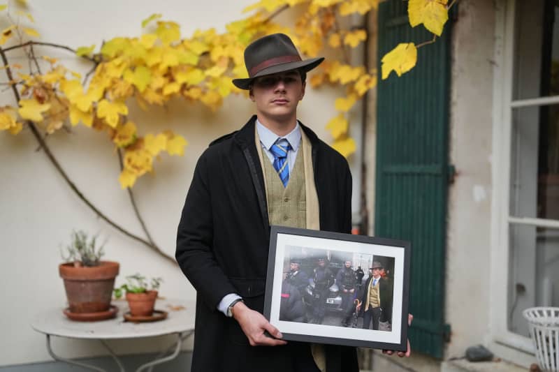 Pedro Elias Garzon Delvaux poses with an Associated Press photo of him outside the Louvre on the day of the crown jewels heist on November 8 in Rambouillet, south of Paris.
