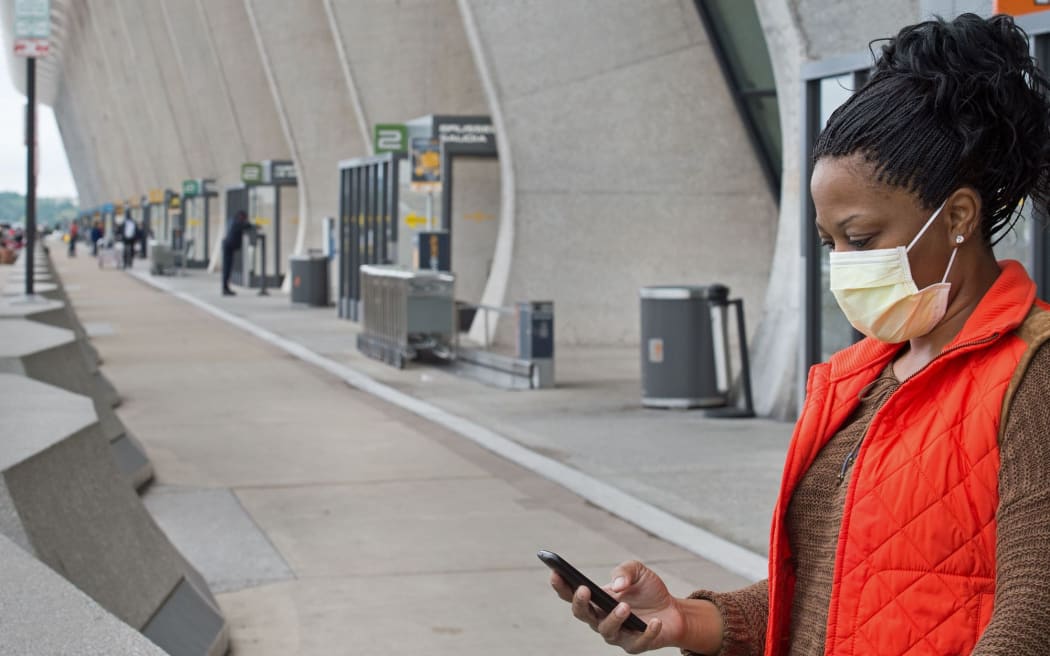 A nurse arriving from Dayton, Ohio, and concerned about Ebola reports, wears a precautionary surgical mask at Dulles International Airport on 16 October.
