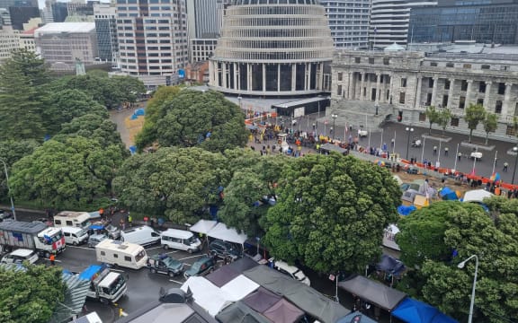 Protesters in Parliament grounds and vehicles blocking the central Wellington street outside.