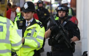 Armed police stand guard outside Parsons Green station