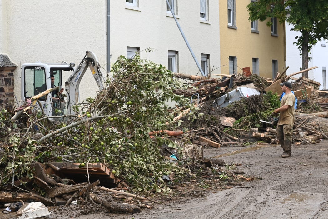 Local residents work on damaged trees in a street in Bad Neuenahr-Ahrweiler, western Germany, on July 16, 2021, after heavy rain hit.