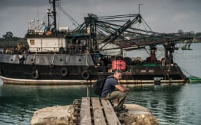 Ian Urbina sitting in front of a Greko vessel