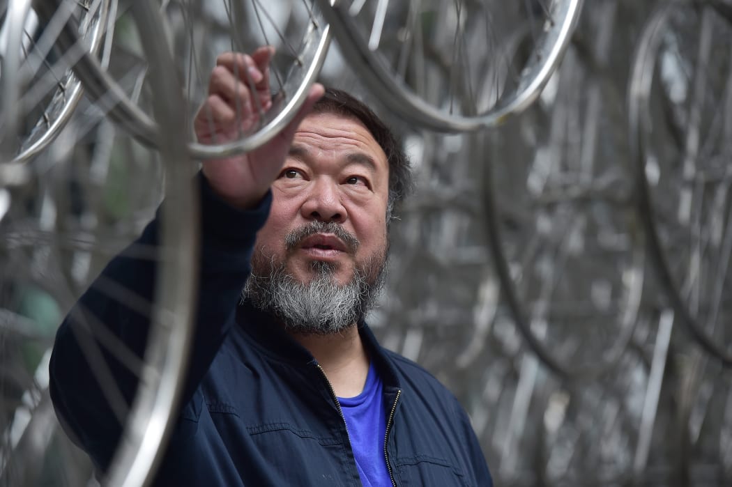 Chinese artist Ai Weiwei touches his sculpture "Forever" at the base of the the "Gherkin" tower in London.