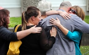 Family members comfort Bryce Jourdain's widow Robyn Jourdain, right, outside the court.