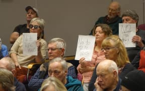 Protestors hold up signs against rates rises.